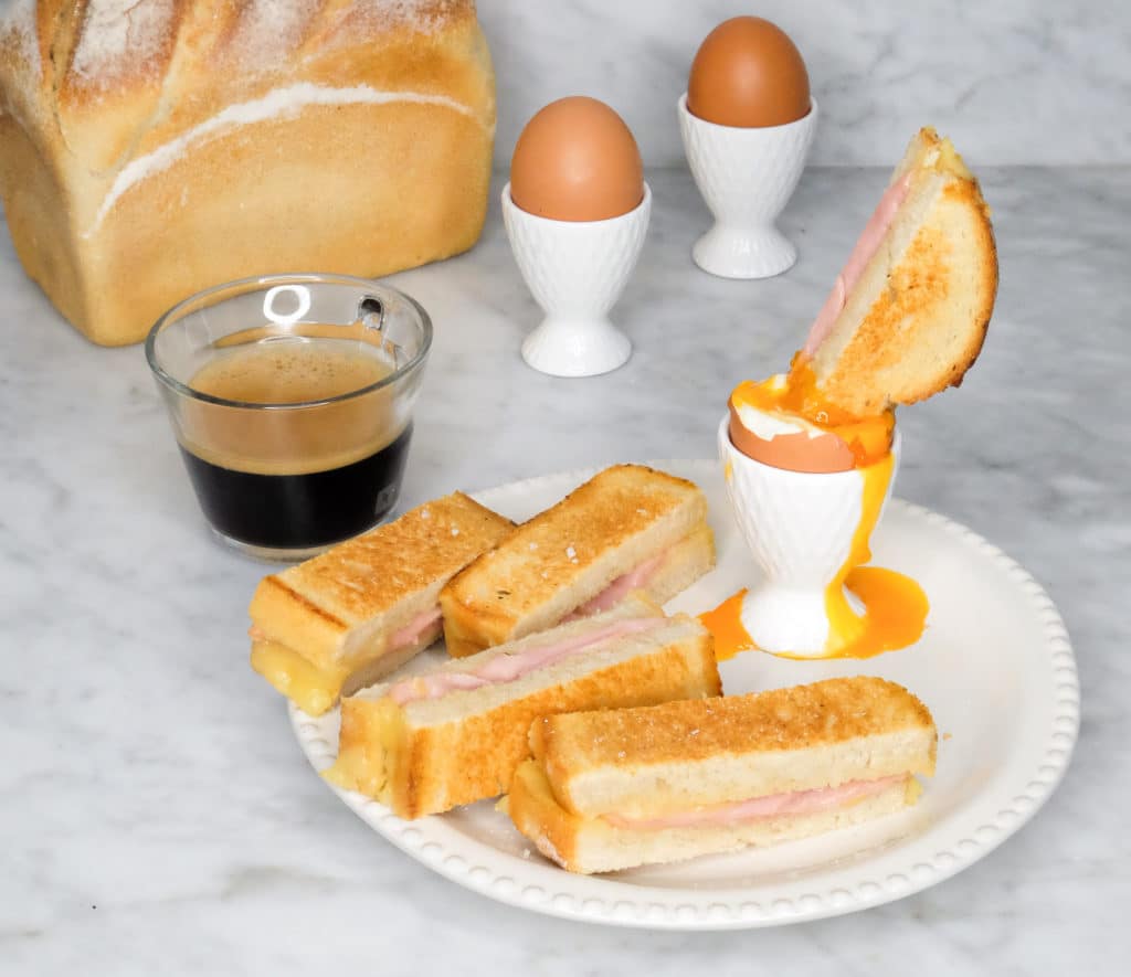 Plate of golden Ham and Cheese Toastie Soldiers served with soft-boiled eggs for dipping, made with Hi Tin Loaf – a fun and tasty Kiwi breakfast.