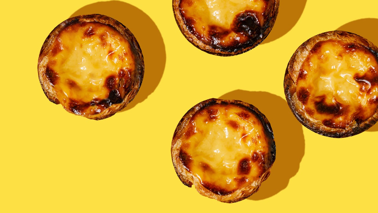 Flaky Portuguese Tarts with creamy custard filling and golden Cruffins layered with buttery pastry and sweet fillings, served as after-dinner treats.